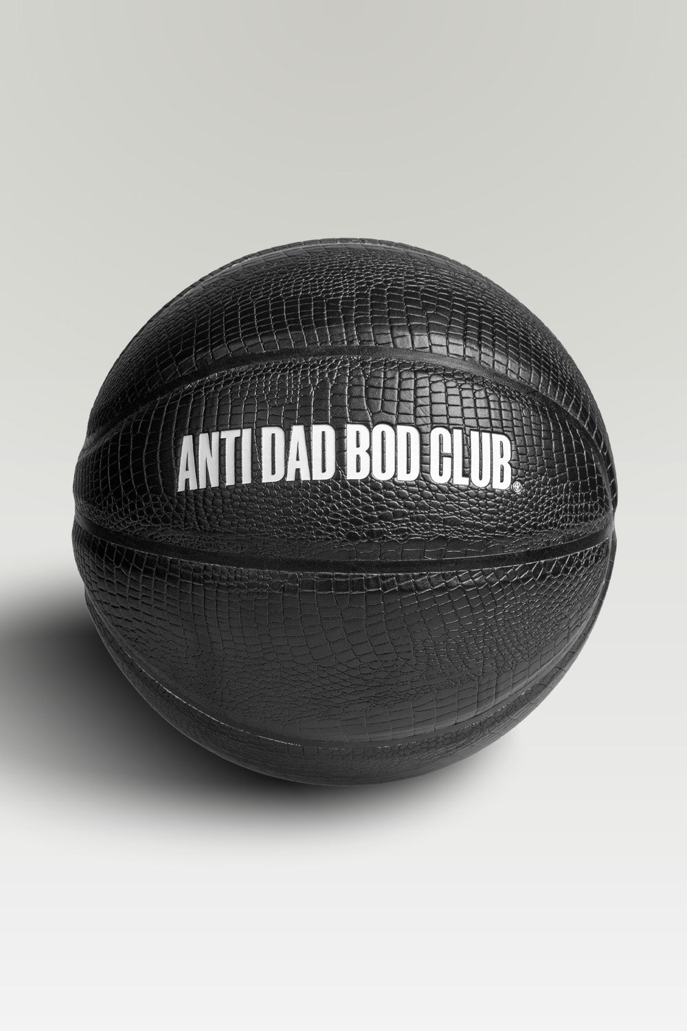 Black textured basket ball with 'Anti Dad Bod Club' text on a light gray background