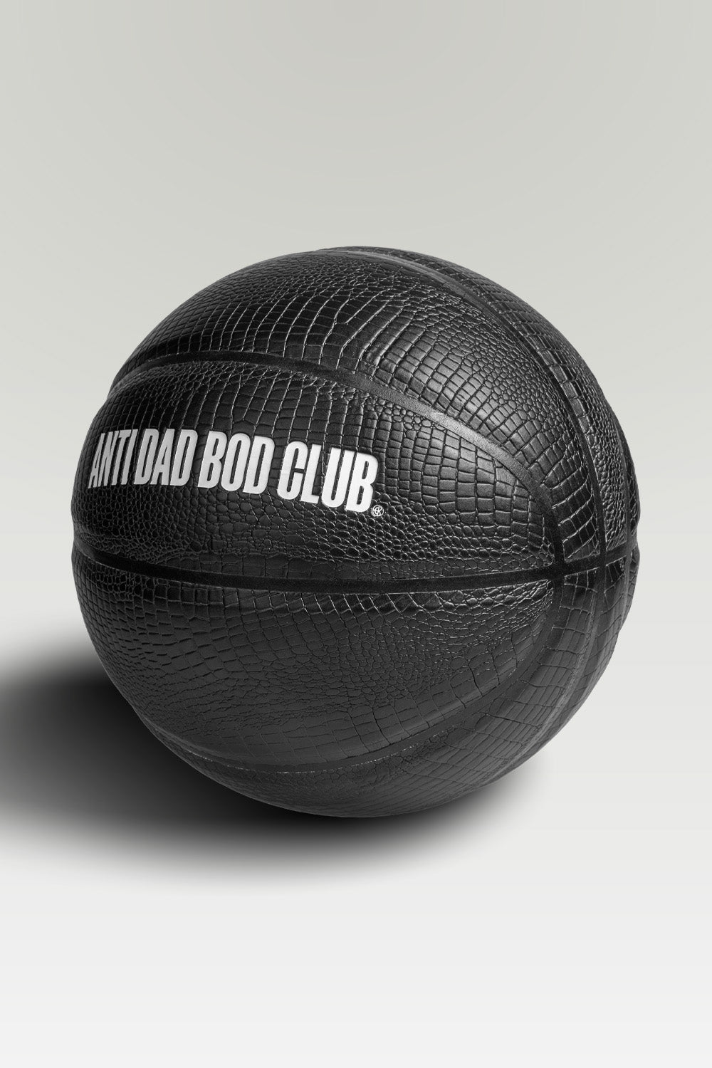 Black textured basket ball with 'Anti Dad Bod Club' text on a light gray background