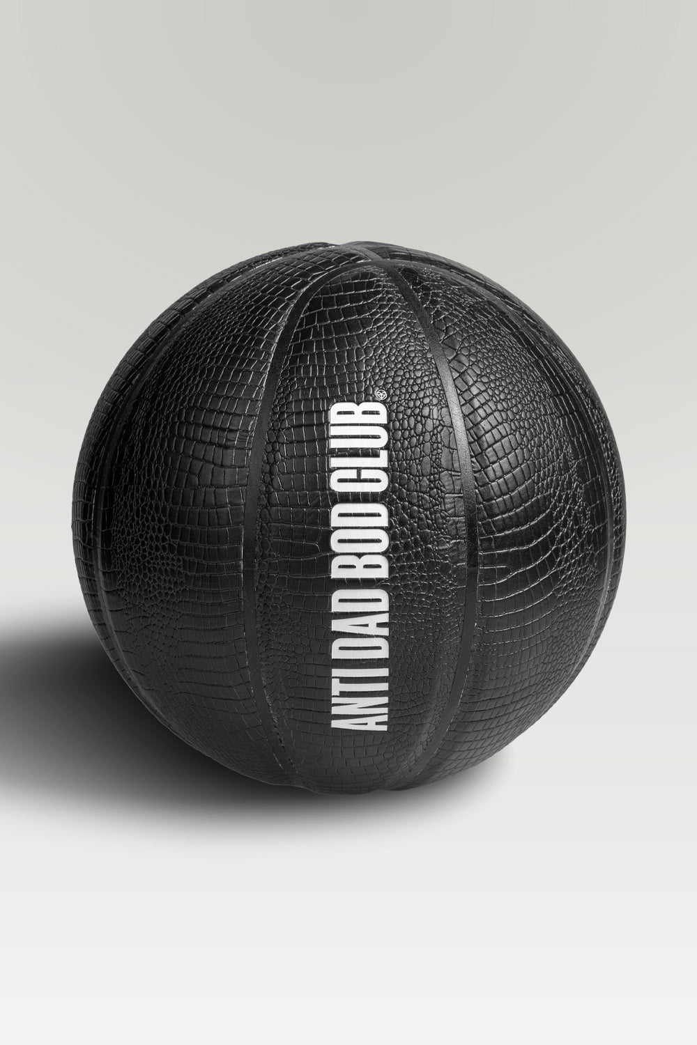 Black textured basket ball with 'Anti Dad Bod Club' text on a light gray background