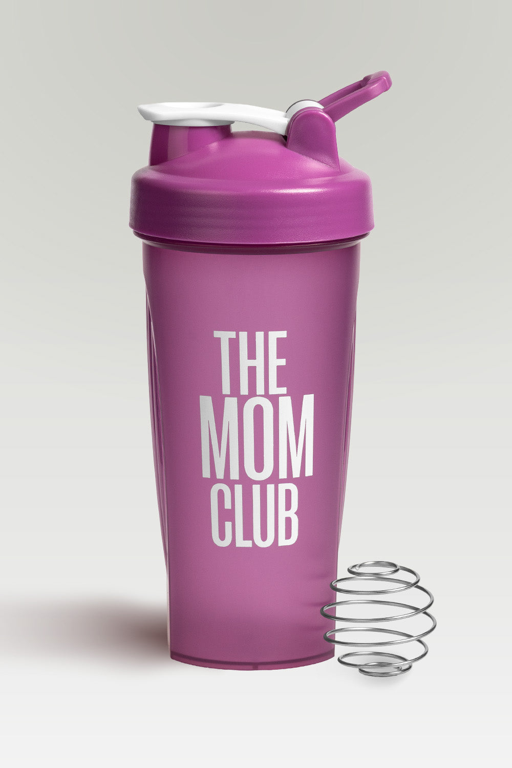 Pink shaker bottle with 'The Mom Club' text on a light gray background